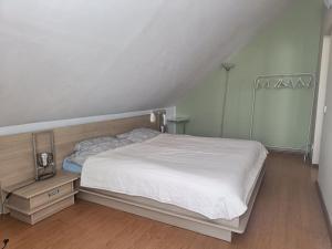 カウナスにあるSpacious Apartment Panemuneのウッドフロアのベッドルーム1室(白いベッド1台付)