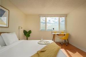um quarto com uma cama, uma secretária e uma janela em Panoramic Penthouse Venice/ Marina Del Rey. em Los Angeles