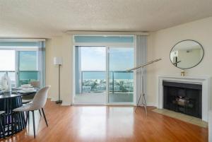 sala de estar con chimenea, mesa y espejo en Panoramic Penthouse Venice/ Marina Del Rey., en Los Ángeles
