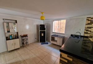 - une cuisine avec un comptoir noir dans une pièce dans l'établissement Casa com piscina na ilha de itaparica, à Vera Cruz de Itaparica