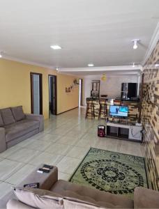 - un salon avec un canapé et une télévision dans l'établissement Casa com piscina na ilha de itaparica, à Vera Cruz de Itaparica