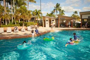 um grupo de pessoas brincando em uma piscina em Brisbane Holiday Village em Brisbane