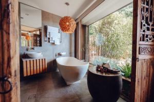 a bathroom with a large tub and a large window at Sticky Rice Villas in Stirling