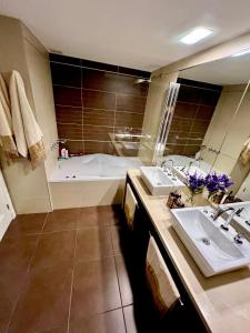 a bathroom with two sinks and a bath tub at Imperialeluxuryapartment in Punta del Este