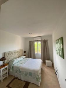 a white bedroom with a bed and a window at Cielo in Concepción del Uruguay