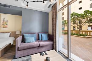 a living room with a couch and a bed at Modern Studio APT Sadaf 6, JBR in Dubai