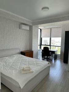 - une chambre avec un lit et un bureau avec une chaise dans l'établissement Platinum apartment, à Bishkek