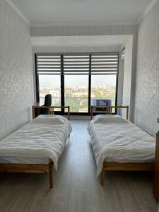 - 2 lits dans une chambre avec une grande fenêtre dans l'établissement Platinum apartment, à Bishkek