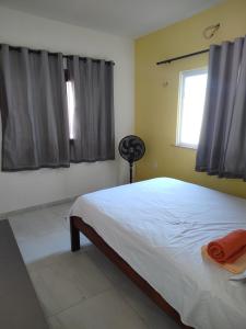 a bedroom with a large bed and a window at Casa Tropicana (2º andar) in Flecheiras