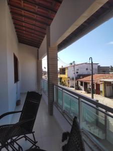 a balcony with chairs and a view of a street at Casa Tropicana (2º andar) in Flecheiras
