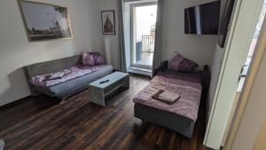 a living room with a couch and a bed and a table at Ferienwohnung in Dresden