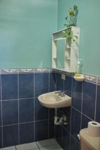 bagno piastrellato blu con lavandino e specchio di Apto casco histórico Acropolis a Comayagua