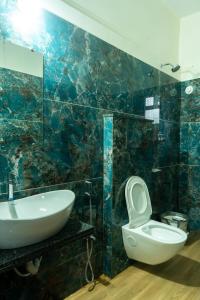 y baño con lavabo, aseo y espejo. en White Water Resort dandeli, en Dandeli