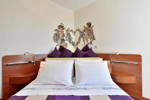 a bedroom with a bed with purple and white pillows at Luxury Seaside Apartment in Split +50 photos