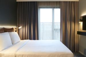 a bedroom with a large bed and a large window at Moxy Chester in Chester