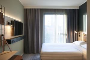 um quarto de hotel com uma cama e uma janela em Moxy Chester em Chester