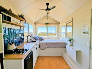 a small kitchen with a bed in a tiny house at Heathcote Hills Tiny House - Tiny Stays in Tooborac
