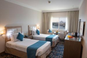 ein Hotelzimmer mit zwei Betten und einem Fenster in der Unterkunft Carlton Tower Hotel in Dubai