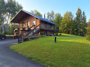a large log cabin with a porch and a lawn at Southern Bluff Bed & Breakfast in Soldotna