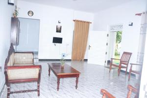 een woonkamer met een tafel en stoelen en een televisie bij Hikkaduwa White Villa near to beach with 3 bedroom in Galle