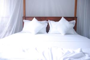 twee witte kussens bovenop een bed bij Hikkaduwa White Villa near to beach with 3 bedroom in Galle