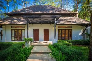 a house with a pathway leading to the front door at Siamdasada Khaoyai in Khao Yai