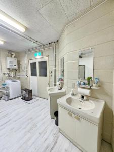 a bathroom with two sinks and a mirror at White House ホワイト ハウス in Shimukappu