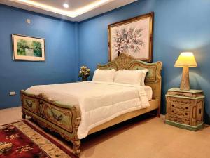 ein Schlafzimmer mit einem großen Bett und einem Nachttisch mit einer Lampe in der Unterkunft Residencia Orlina in Dumaguete