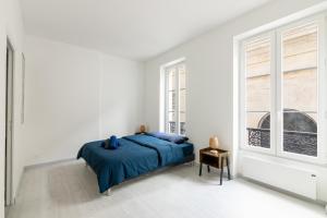 a white bedroom with a bed and a window at Luxurious 2 Bedroom Avenue des Champs-Élysées Saint-Philippe du Roule Free Netflix in Paris