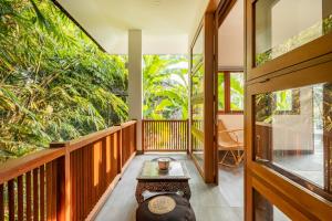 Zimmer mit einem Balkon mit einem Tisch und einigen Bäumen in der Unterkunft Villa Nya Ubud in Ubud