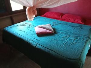 a bed with two pillows on top of it at Fandee Island - Secret Private House - Tad Lo Bolaven Loop Pakse in Ban Kiangtat