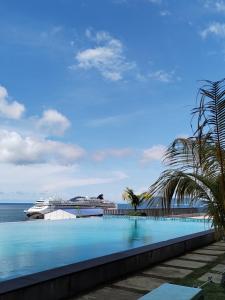 a cruise ship in the ocean next to a swimming pool at ArasTwo JQ Homestaykk LEVEL 22 SEAVIEW in Kota Kinabalu