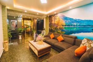 una sala de estar con sofá y una pintura de un lago en Le Tuan Minh Hotel, en Da Lat