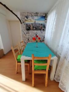 einen Tisch mit Stühlen und eine Vase mit Blumen darauf in der Unterkunft Apartment Irina in Pirmasens