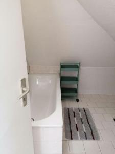 a white bathroom with a green chair and a rug at Apartment Irina in Pirmasens