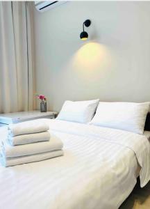 a bedroom with a white bed with towels on it at Mira Apart-Hotel in Kyiv