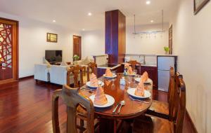 a dining room with a table and a living room at Sunny Beach Resort & Spa in Mui Ne