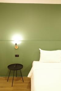 a bedroom with a bed and a table and a lamp at NOW’S HOSTEL in Ban Chang