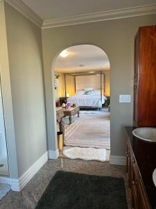 ein Badezimmer mit einem Schlafzimmer mit einem Bett darin in der Unterkunft Royal highland livingroom bedroom suite in Calgary