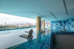 a balcony with chairs on a building with water at Blissful Cottage@FeelHome/2BR,7pax,MRT 中文房东 in Kuala Lumpur