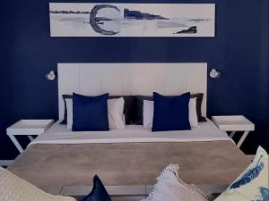 a bedroom with a large bed with blue walls at The Daiquiri Shaq in St Helena Bay