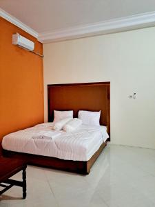 a bedroom with a large bed with a wooden headboard at Kresna Guest House Syariah Pacitan in Pacitan
