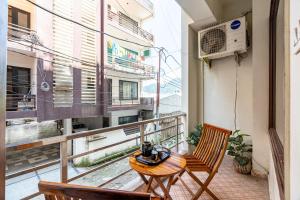 a balcony with a table and chairs and a window at Homlee - Hill View Apartment Luxury in Rishīkesh