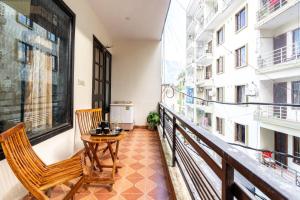 a balcony with two chairs and a table on it at Homlee-Jumbo 1BHK-2AC-Kitchen-Lift-Parking-Tapovan in Rishīkesh