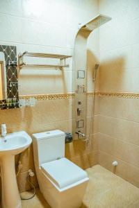 La salle de bains est pourvue de toilettes, d'un lavabo et d'une douche. dans l'établissement Ekefaru Inn, à Viligili