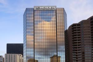 un bâtiment miroir avec un panneau en haut dans l'établissement Le Méridien New Orleans, à La Nouvelle-Orléans