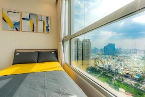 a bed in a room with a large window at Raddison Luxury Apart - Vinhome Central Park, Landmark 81 Area and Great Park in Ho Chi Minh City