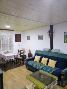 a living room with a blue couch and a table at Kućica za odmor-Borova glava in Zlatibor