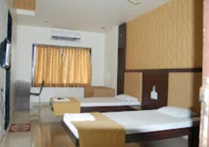 Habitación hospitalaria con 2 camas y ventana en Hotel Sangram Palace Shirur, en Sirūr