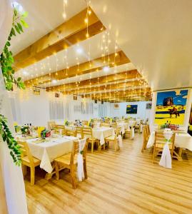 にあるTungalag tamir tourist campの白いテーブルと椅子、照明が備わるレストラン